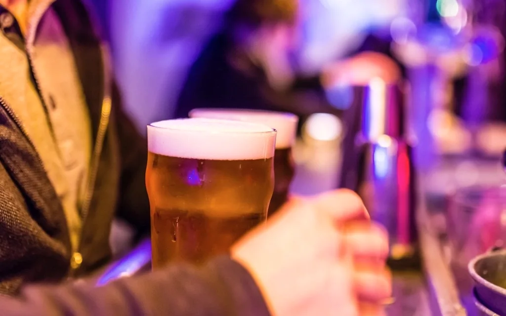 Chope servido no balcão de um bar à noite